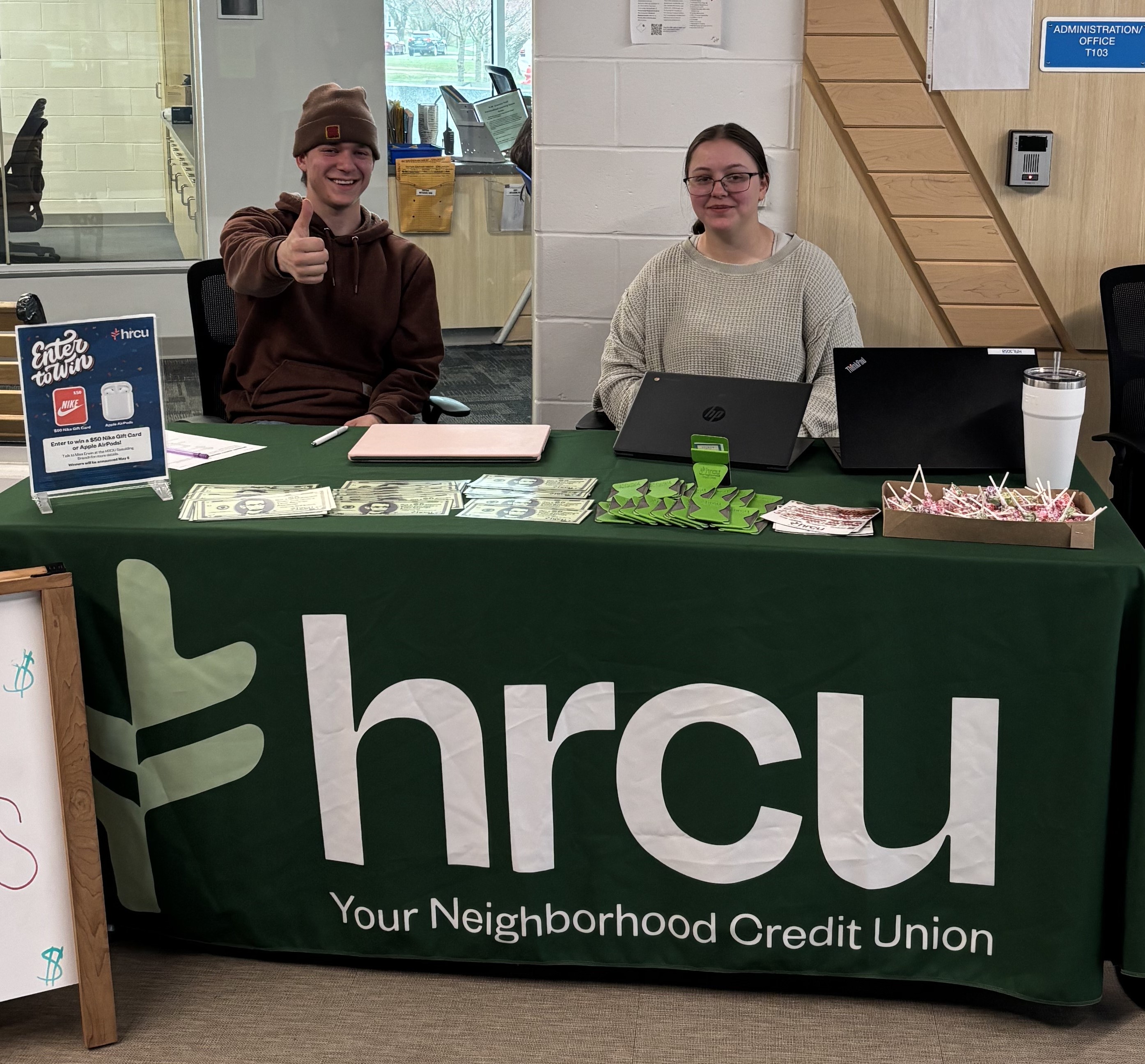 <p>SHS students KJ Fry (left) and Kaylee Merrifield (right) sitting outside the SHS branch promoting Credit Union Youth Month to their fellow students.</p>